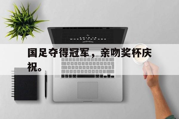 国足夺得冠军，亲吻奖杯庆祝。
